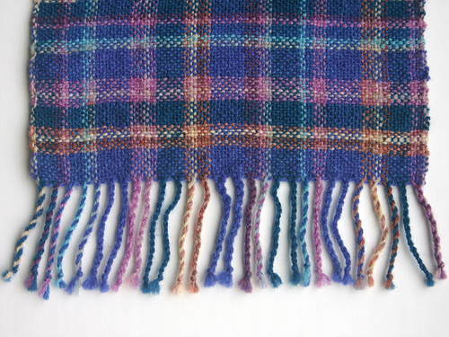 Plaid detail and tassels from one end of the Magnolia wrap
