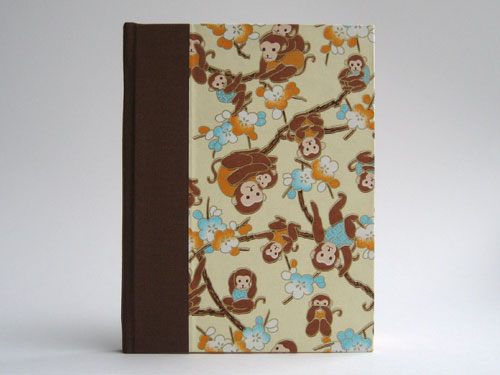 Front view: Chiyogami paper with mama and baby monkeys hanging out in cherry blossoms, brown bookcloth
