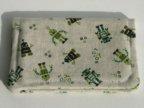 Front view of card wallet: green and brown cartoon robots on linen
