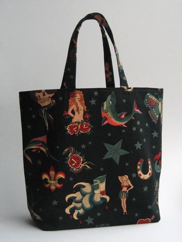 Tote bag in black fabric with images inspired by old sailor tattoos (mermaids, hula dancers, etc)