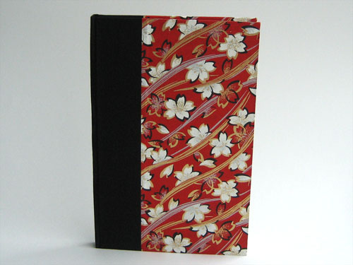 Front view: gold and white leaves swirling on a red background, black book cloth