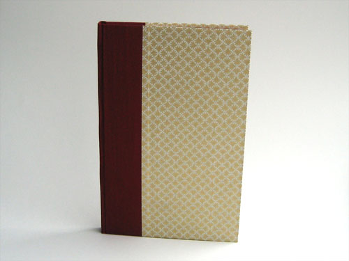 Front view: gold and white patterned paper with deep red book cloth