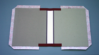 Back view of cover boards with decorative paper attached and corners trimmed