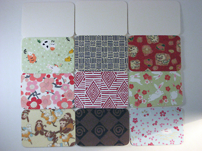 Several gift cards with strips of decorative paper glued to the top