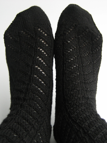 Diagonal lace socks, worn, showing the lace pattern mirrored on the second sock