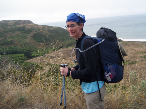 Side view of me wearing a backpack, with the California coast in the background