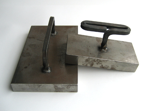 Two steel rectangles of various sizes, about 1 inch thick, with steel handles welded on.