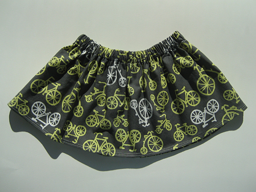 A gathered skirt featuring yellow and white bicycles on a gray background